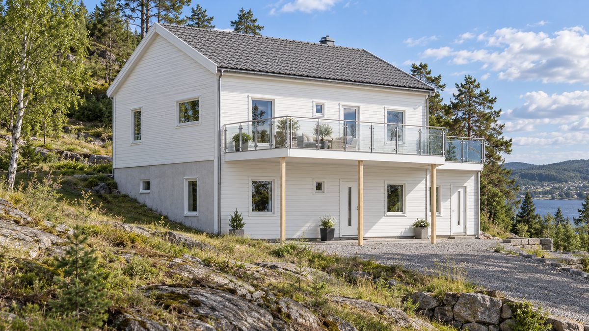 Illustration av ett vitt suterränghus med terrasser på en kuperad tomt
